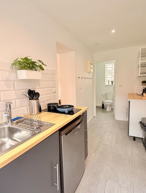 A modern kitchen with a dishwasher, a sink, and a countertop. There is a window with a view of the outside. - Le BARN -> a stylish urban retreat ❤️ (Le Havre)