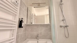 A bathroom with a white sink, a mirror, a handheld showerhead, and a towel rack. - Le BARN -> a stylish urban retreat ❤️ (Le Havre)