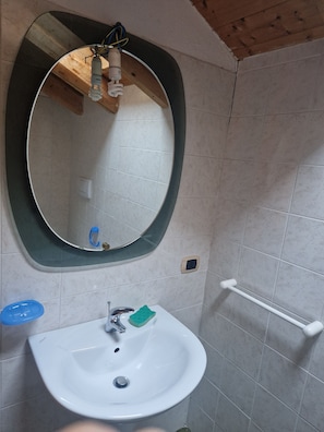 A bathroom with a white sink, a mirror, and a towel rack.