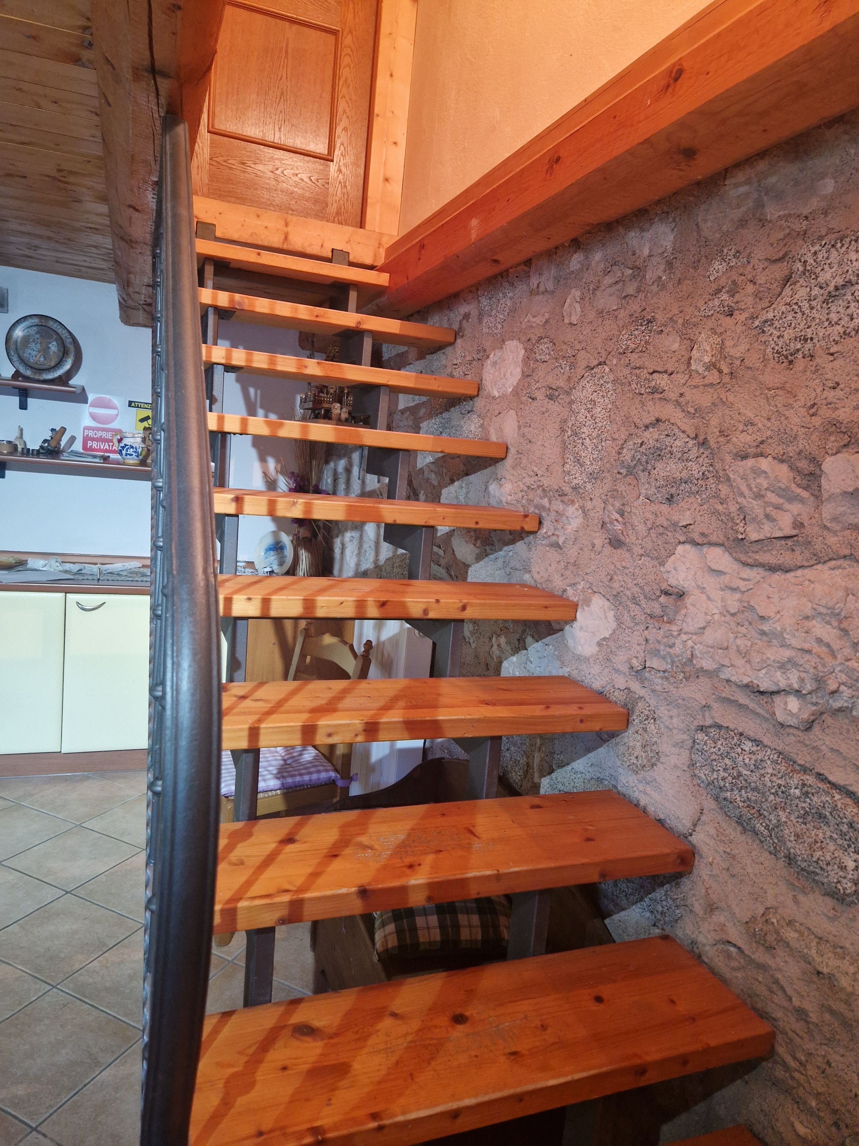 Eine Holztreppe mit einer rustikalen Steinwand.