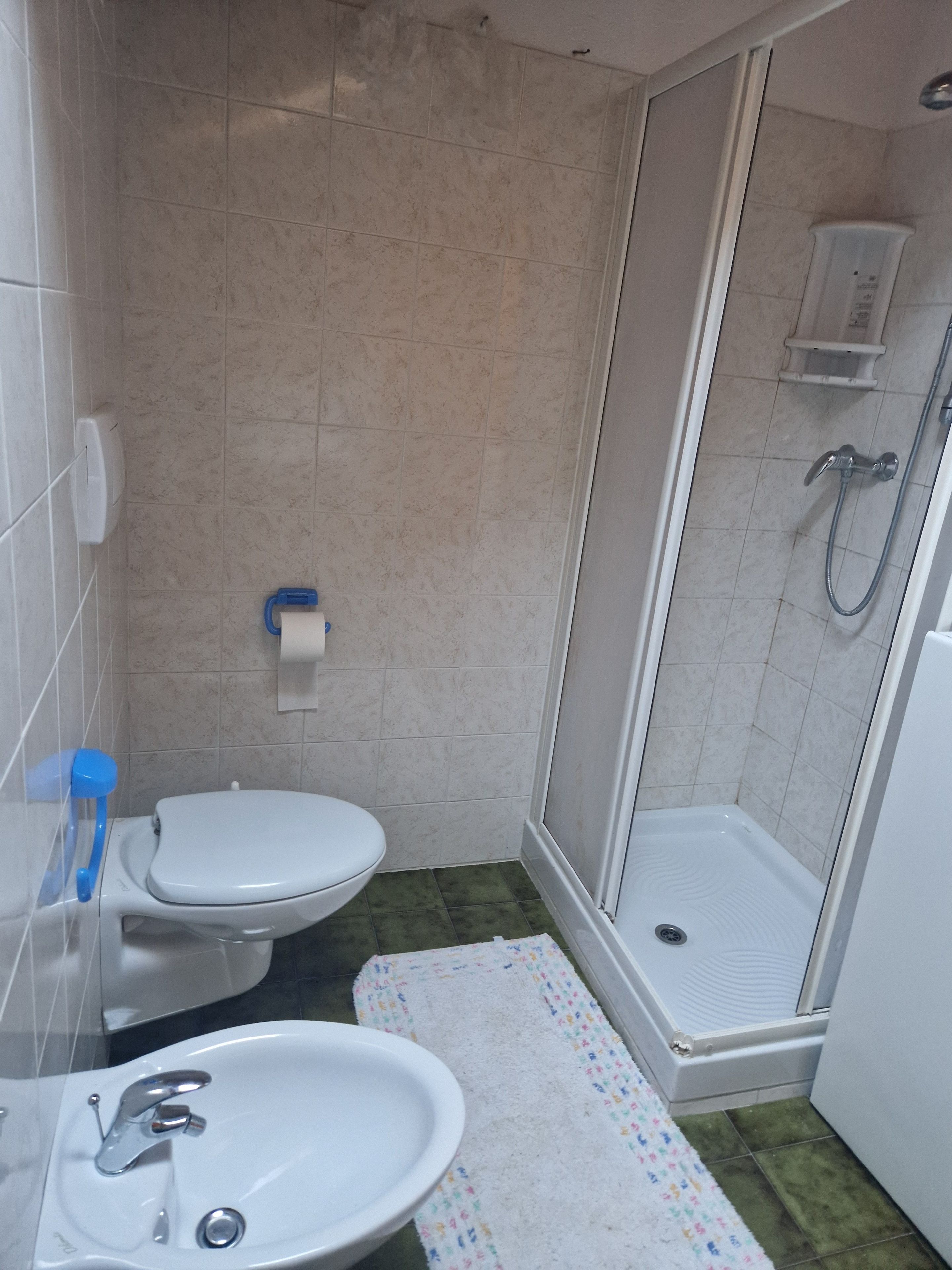 A bathroom with a toilet, sink, and shower.