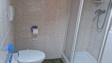 A bathroom with a toilet, sink, and shower.