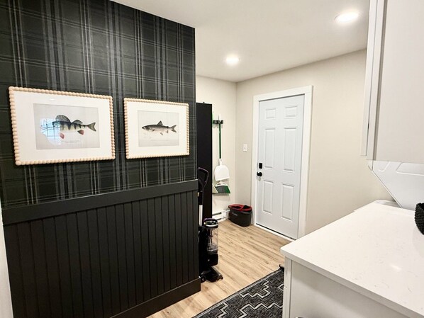 Une salle de bain avec un meuble-lavabo noir, un lavabo blanc et des tableaux représentant des poissons accrochés au mur.