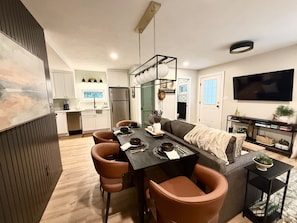 Una cocina moderna con comedor, sofá y televisor.