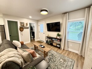 A modern living room with a sofa, coffee table, and a flat-screen TV.