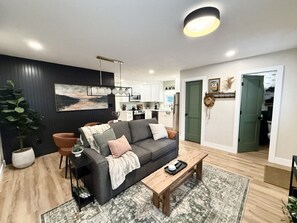 Un salon moderne avec un canapé, une table basse et un grand tableau accroché au mur.