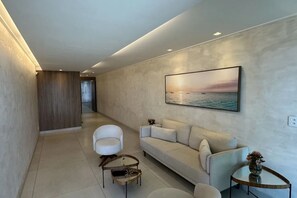 A modern living room with a sofa, a chair, and a coffee table. - BNB Flex Comfort (Recife)