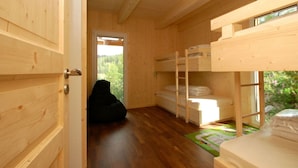 A wooden interior with bunk beds, a door leading outside, and a mat on the floor. - Cabin in Turrach With Sauna and Wi-fi (Stadl-Predlitz)