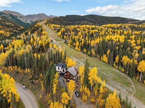 A lodge surrounded by a forest with a winding road. - Sundancer Lodge - True Ski-In/Out+Hot Tub+Views (Mountain Village)