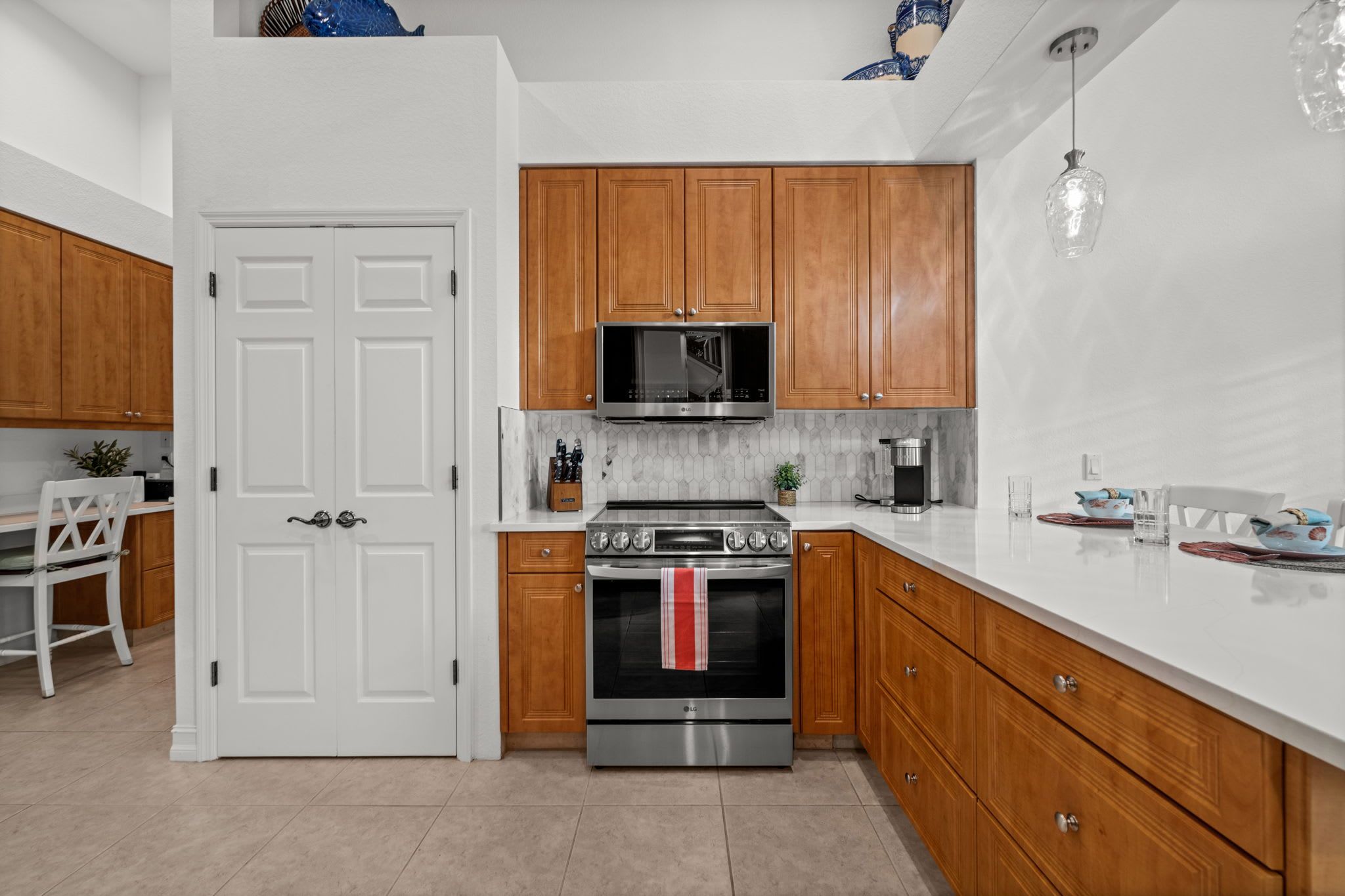 A modern kitchen with wooden cabinets, a stainless steel stove, and a microwave.