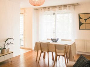 Un comedor con una mesa, sillas, un bol, una planta y un radiador.