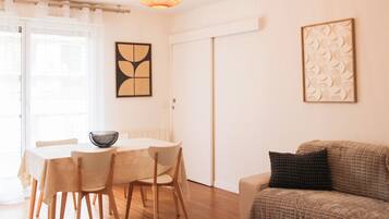 Una sala de estar moderna con comedor, un sofá, una mesa de centro y una lámpara decorativa.