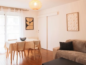 Una sala de estar moderna con comedor, un sofá, una mesa de centro y una lámpara decorativa.