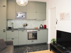A modern kitchen with a built-in oven, microwave, and a coffee maker on the countertop. - One-bedroom apartment for 4 guests in Paris 9 (Paris)