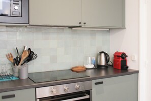 A kitchen with a microwave, a kettle, and a red appliance on the counter. - One-bedroom apartment for 4 guests in Paris 9 (Paris)