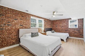 A room with two beds, a brick wall, and a ceiling fan. - Spacious 4-bedroom house in beautiful Taylors - 10 min drive from DT Greenville (Taylors)