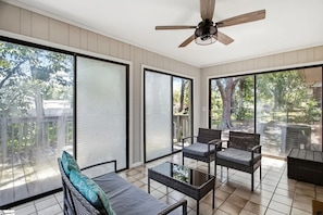 A sunlit room with a ceiling fan, large sliding glass doors, wicker furniture, and a tiled floor. - Spacious 4-bedroom house in beautiful Taylors - 10 min drive from DT Greenville (Taylors)