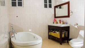 Ein Badezimmer mit Badewanne, Toilette, Waschbecken und Spiegel.