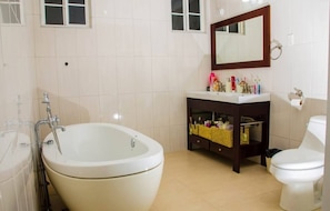 A bathroom with a bathtub, a toilet, a sink, and a mirror. - Da Villa Juanita (Hordley)