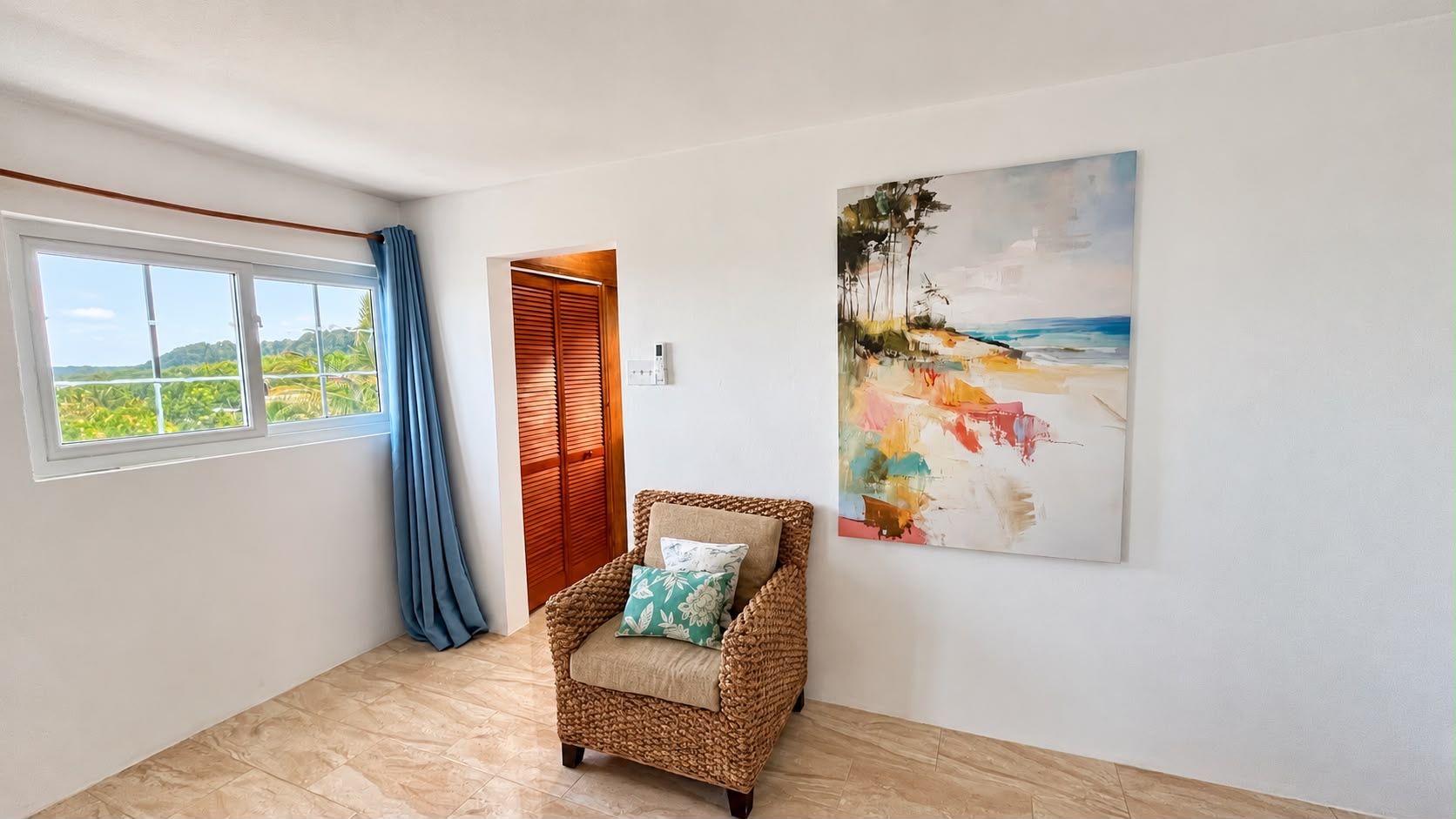 Une pièce avec une grande fenêtre, un fauteuil en osier et un tableau accroché au mur.