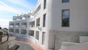 A multi-story building with balconies, a stone facade, and a clear sky. - ‘In Inbisa’ Apartment with Sea Views, Wi-Fi & Air Conditioning (Mijas)
