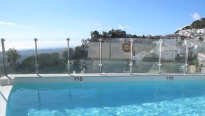 A clear swimming pool with a view of a residential area and a hill in the background. - ‘In Inbisa’ Apartment with Sea Views, Wi-Fi & Air Conditioning (Mijas)