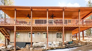 A two-story wooden building with a balcony, construction materials scattered around, and a clear sky. - Ricks Mountain Retreat (Sedalia)