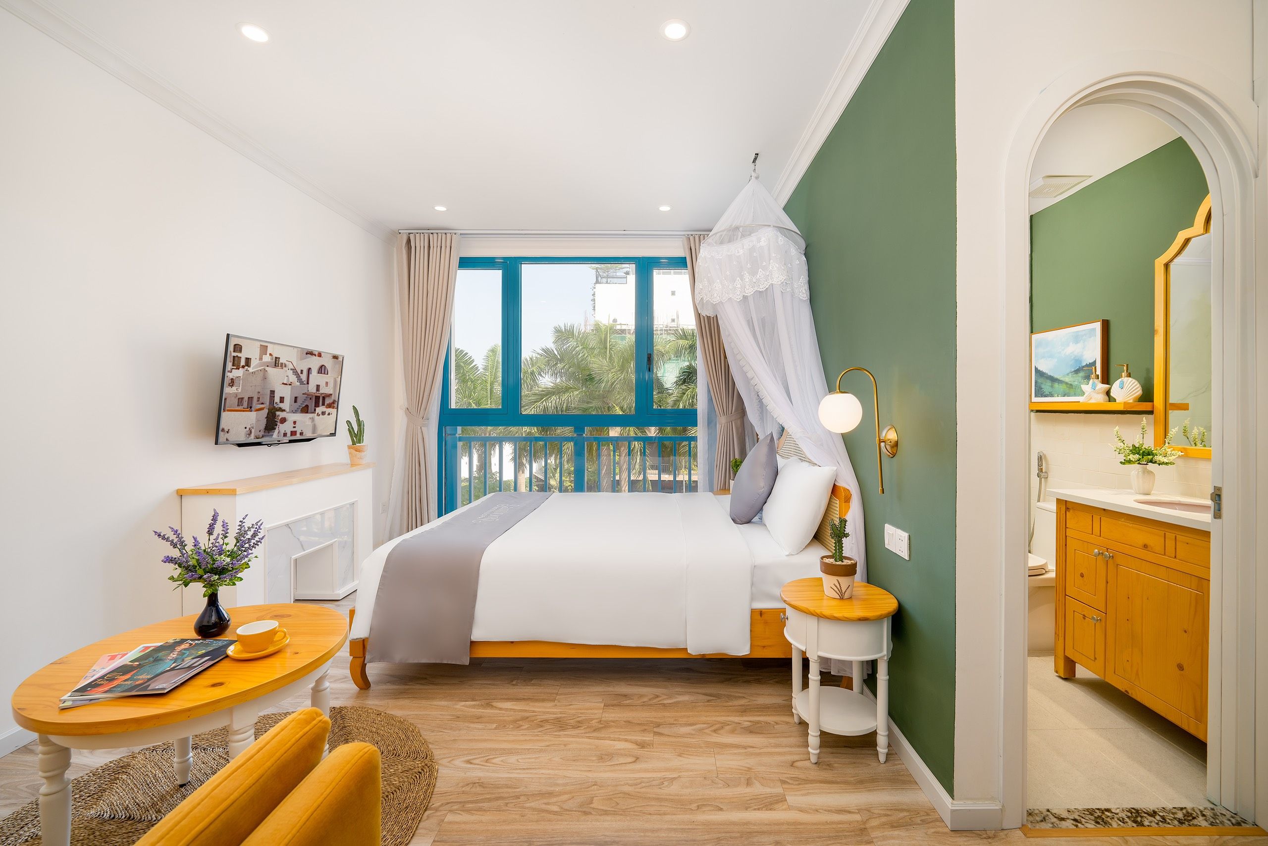 A bedroom with a bed, bedside table, and a view of the outdoors.