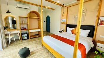 A bedroom with a bed, a desk, a wardrobe, a mirror, and a door.