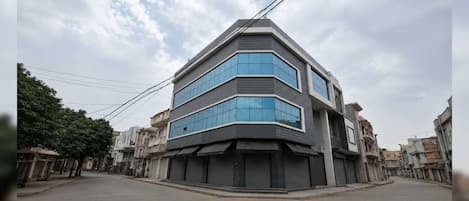 A modern building with a corner design, featuring large windows and a flat roof.