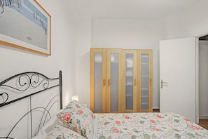 Ein Schlafzimmer mit Bett, Kleiderschrank und Tür.