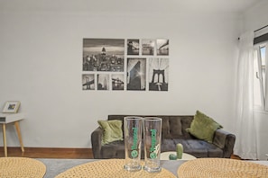 Ein Wohnzimmer mit Couch, Couchtisch und einer Wand voller gerahmter Bilder.