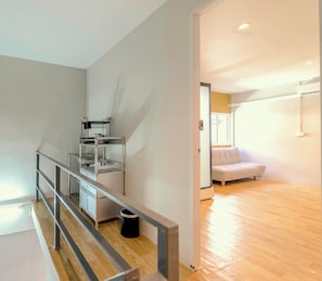 A modern interior with a staircase, a sofa, and a kitchen area. - Ren Phayathai (Krung Thep Maha Nakhon)