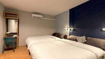 Un dormitorio con una cama grande, un escritorio con silla, un espejo, un equipo de aire acondicionado y una lámpara de pared.