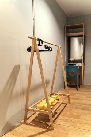 A room with a wooden swing set against a wall, a blue chair, and a mirror reflecting a door. - Ren Phayathai (Krung Thep Maha Nakhon)