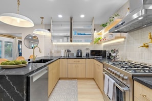 Una cocina moderna con una isla central, electrodomésticos de acero inoxidable y varios armarios de almacenamiento.