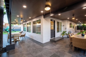 A modern interior with a dining area, a play area visible through the windows, and a staircase leading to the upper level. - The Enchanted Estate , 5 Bed Rooms - 3 Bathrooms - Luxury Resort Near Disneyland (Anaheim)