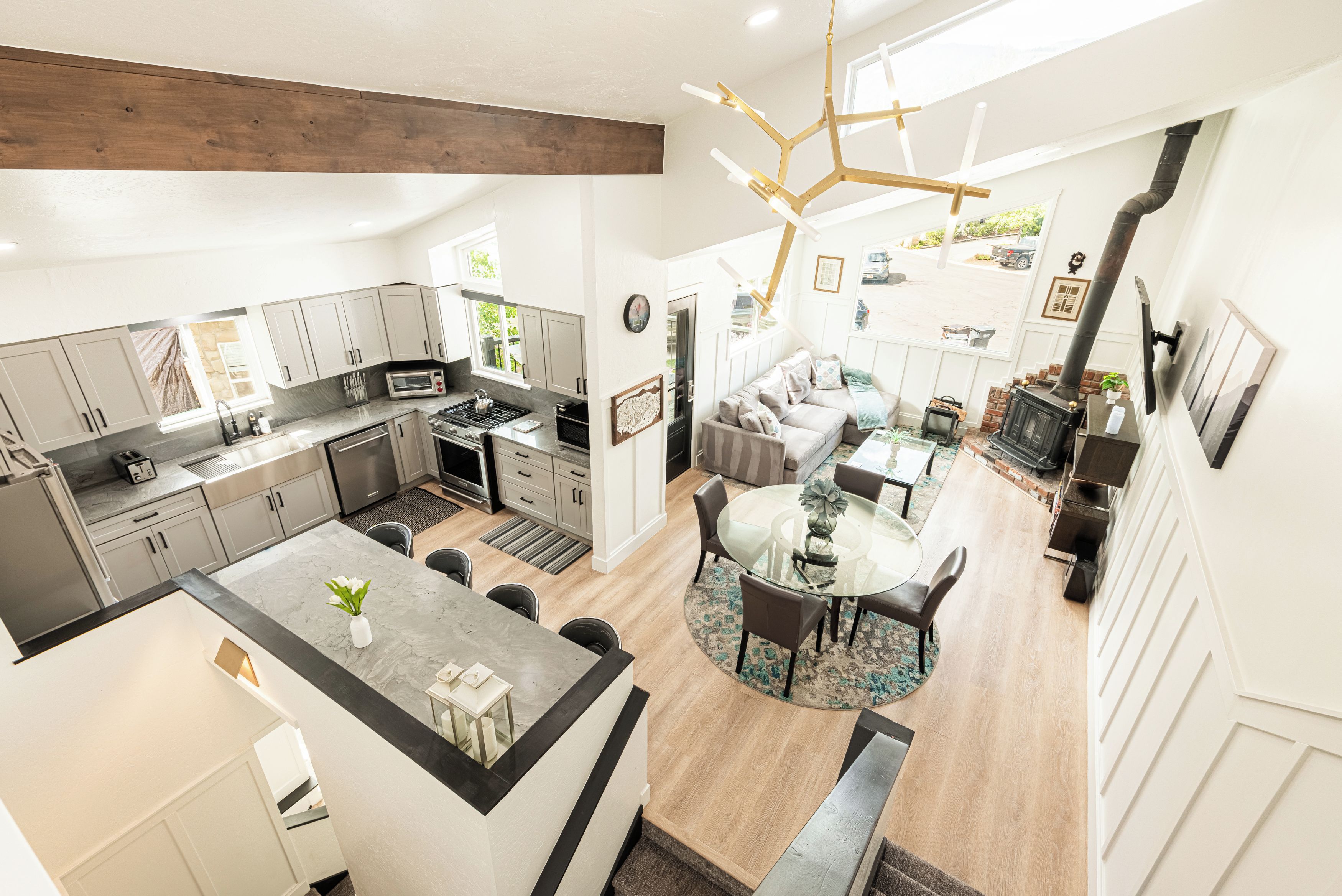 A spacious kitchen with modern appliances, a dining area with a glass table, and a cozy seating area with a fireplace.