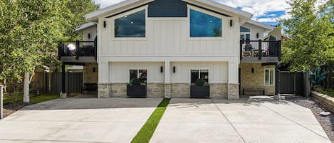A two-story house with a central entrance, a covered porch, and a stone foundation.