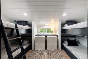 A compact, well-lit dormitory room with bunk beds, a small desk, and a window providing a view of greenery outside. - Park City Ski Getaway | Private Hot Tub | Fireplaces | Sleeps 10 (Park City)