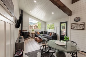A cozy living room with a fireplace, a sofa, a coffee table, and a dining area with a glass table. - Spacious 4BR townhome for 10 in Park City's Prospector Square. (Park City)