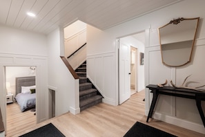 A modern interior with a staircase leading to a bedroom, a hallway with a mirror and antlers, and a wooden floor. - Spacious 4BR townhome for 10 in Park City's Prospector Square. (Park City)