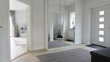 Un interior moderno con separador de vidrio, piso de madera y puerta con paneles de vidrio esmerilado.