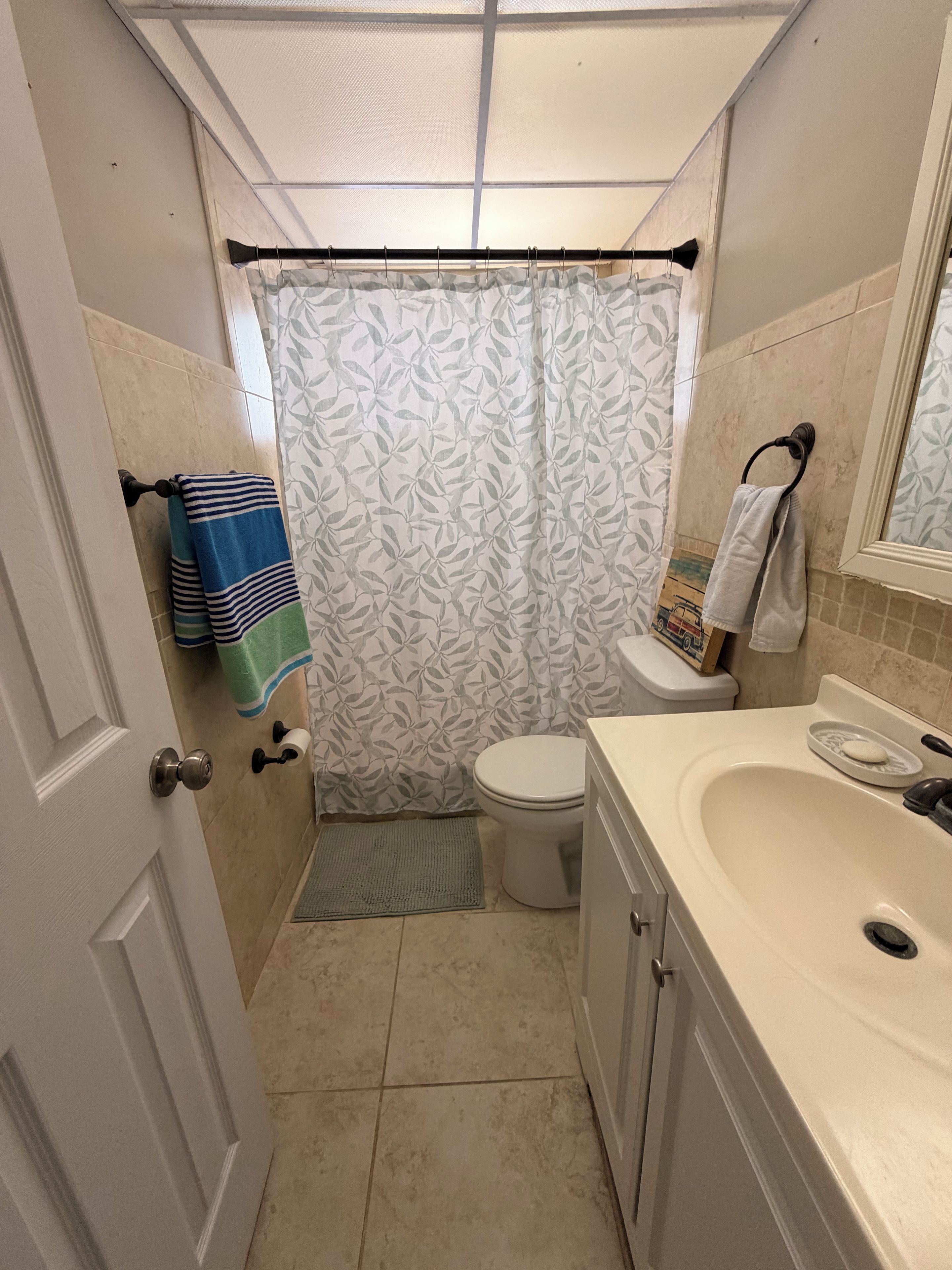 A bathroom with a toilet, sink, and shower curtain.