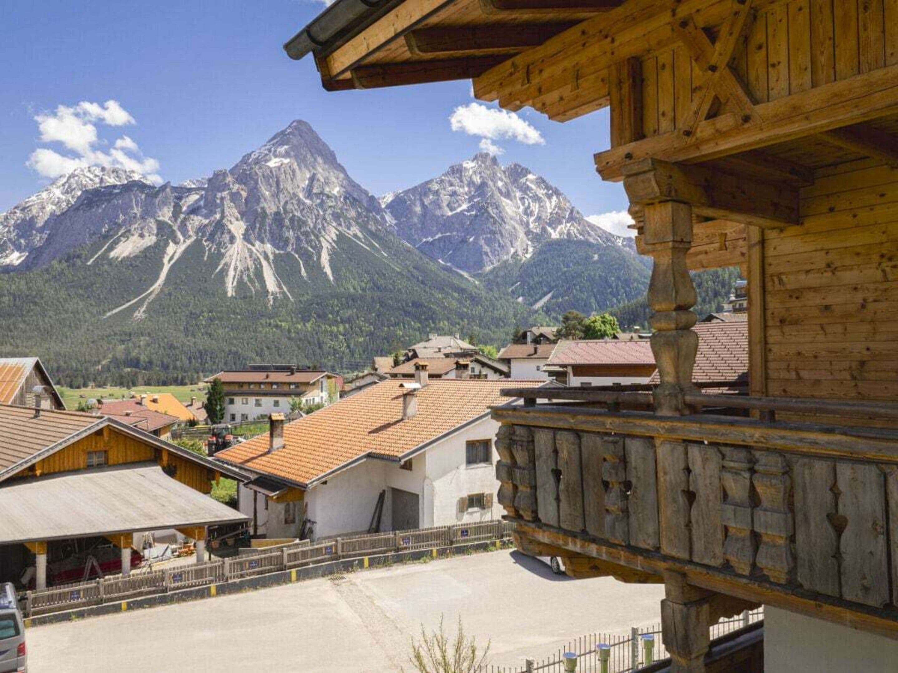 A wooden building with a balcony overlooking a mountainous landscape.