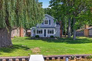 A two-story house with a front porch and a small front yard. - Lakefront Cottage w/ Sunset Views and Private Dock (Brooklyn)