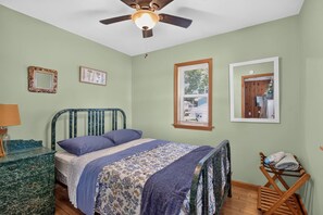 A bedroom with a bed, a ceiling fan, a dresser, and a chair. - Lakefront Cottage w/ Sunset Views and Private Dock (Brooklyn)