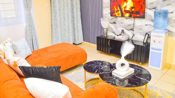 Una sala de estar con un sofá, una mesa de centro, una chimenea y un dispensador de agua.