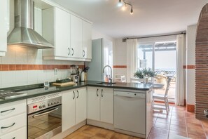 A modern kitchen with white cabinetry, a Bosch dishwasher, and a built-in oven. - Vacation Home 'Vistas De Ensueño' with Sea Views, Wi-Fi, and Air Conditioning (Almuñécar)