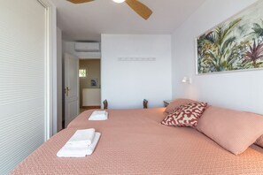 A bedroom with a bed, a ceiling fan, a painting, and a door. - Vacation Home 'Vistas De Ensueño' with Sea Views, Wi-Fi, and Air Conditioning (Almuñécar)